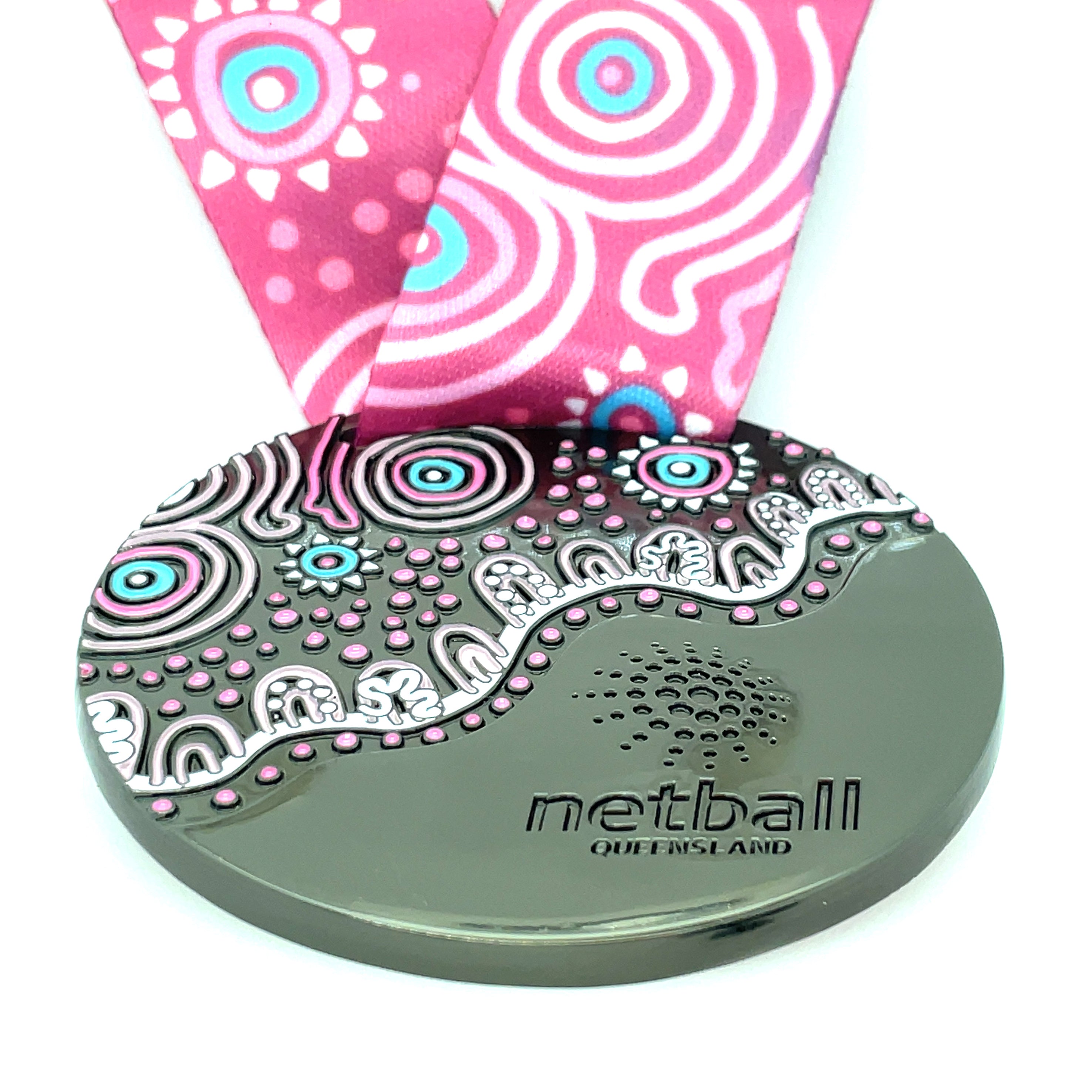 Decorative netball medal with a pink and white patterned ribbon on a white background