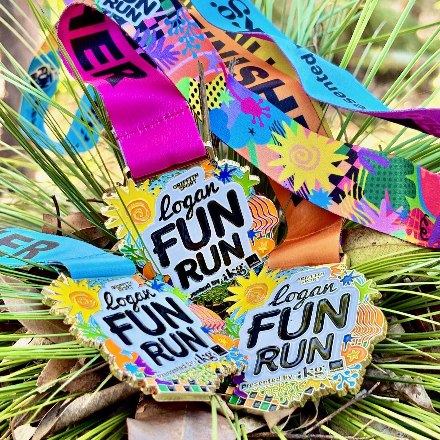 Colorful 'Logan Fun Run' medals on a green leaf background
